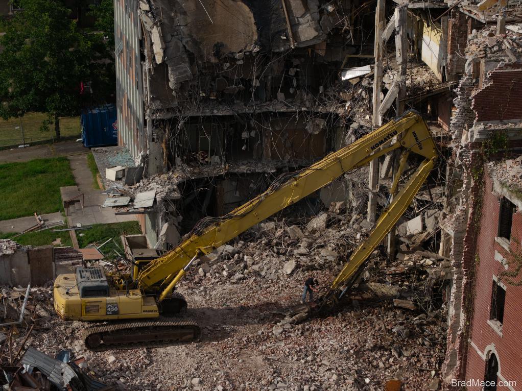 Aerial view of excavator tearing down commercial building
