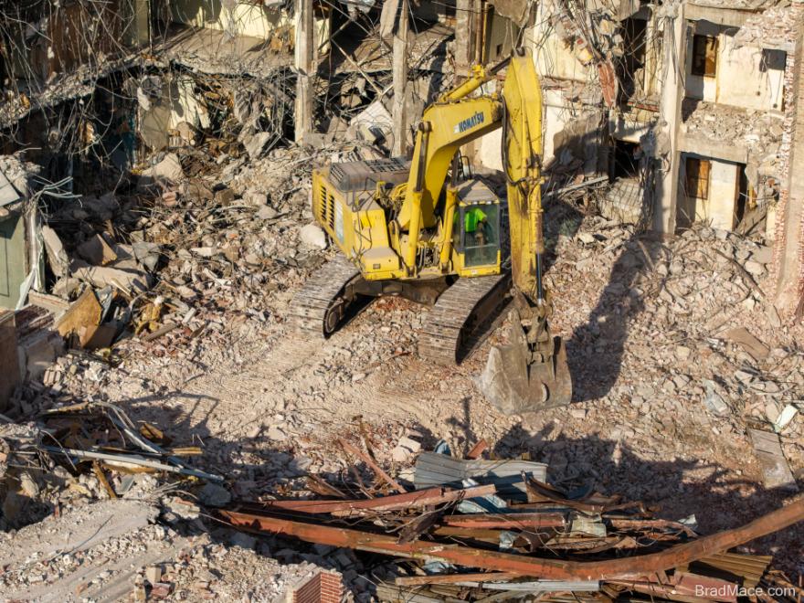 Aerial view of excavator clearing demolition rubble
