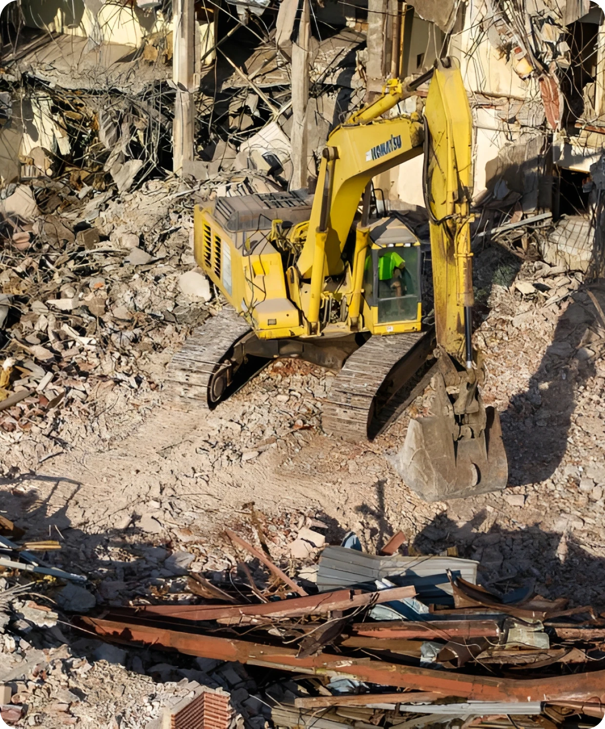 Komatsu excavator working through demolition debris and rubble
